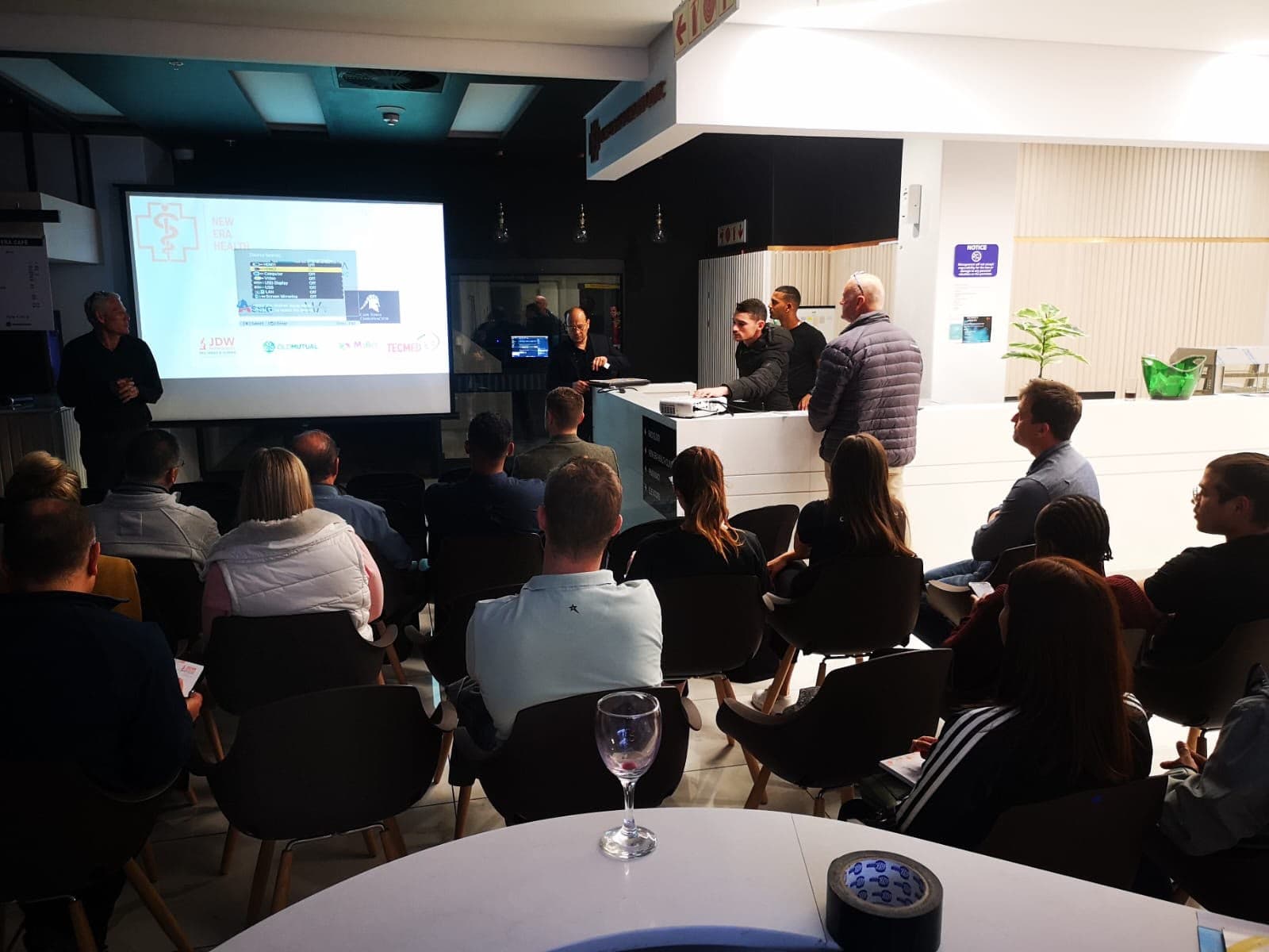 Healthcare professionals watching a presentation at an evening MedTalk Network CME event